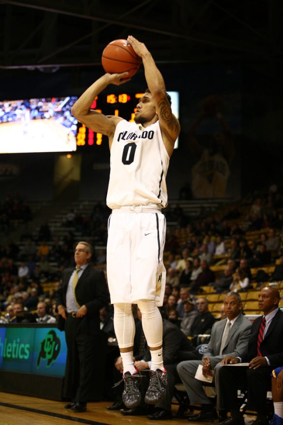Junior guard Askia Booker (0) shoots a 3-pointer in the first half. (Kai Casey/CU Independent)