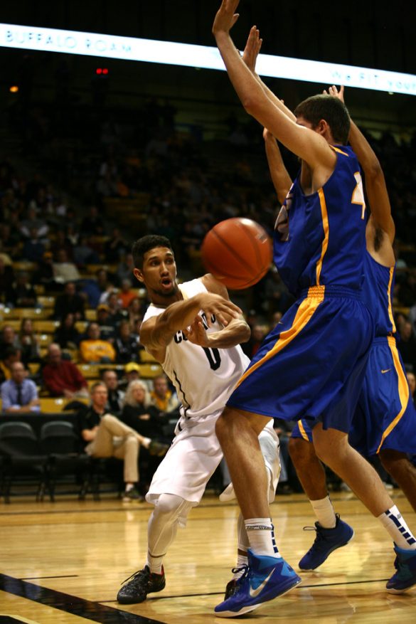 Junior guard Askia Booker (0) passes on the baseline. (Kai Casey/CU Independent)