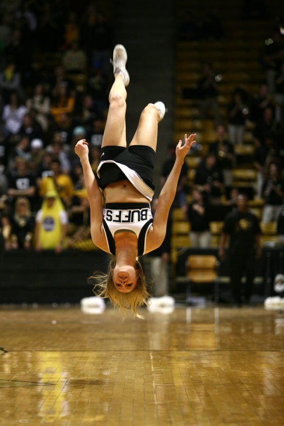 A CU cheerleader does a back flip during a timeout. (Kai Casey/CU Independent)