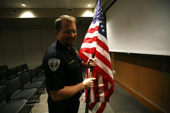 CU Police Department Cmdr. Robert Axmacher sets up an American flag before a Lifesaving Awards ceremony, Monday, in the Kittredge Central Multipurpose Room. Three students received the Lifesaving Award, the highest CU police honor presented to the public, for saving an 80-year-old man's life in August in the Center for Community. (Kai Casey/CU Independent)
