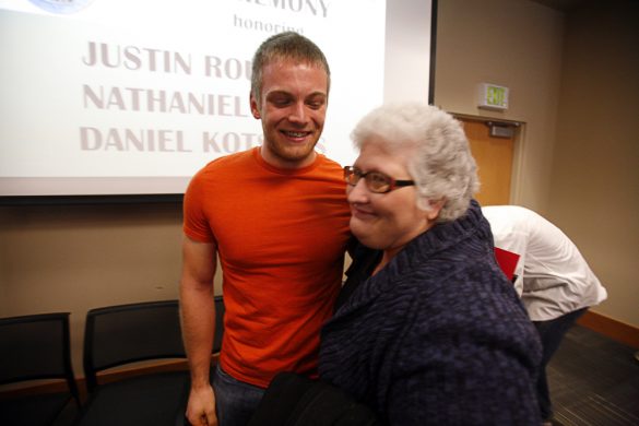 Paula Brand, director of residential life at CU, hugs Nathaniel Pohl, a residential advisor in Aden Hall, after Pohl received a Lifesaving Award for saving an 80-year-old man's life in August. (Kai Casey/CU Independent)