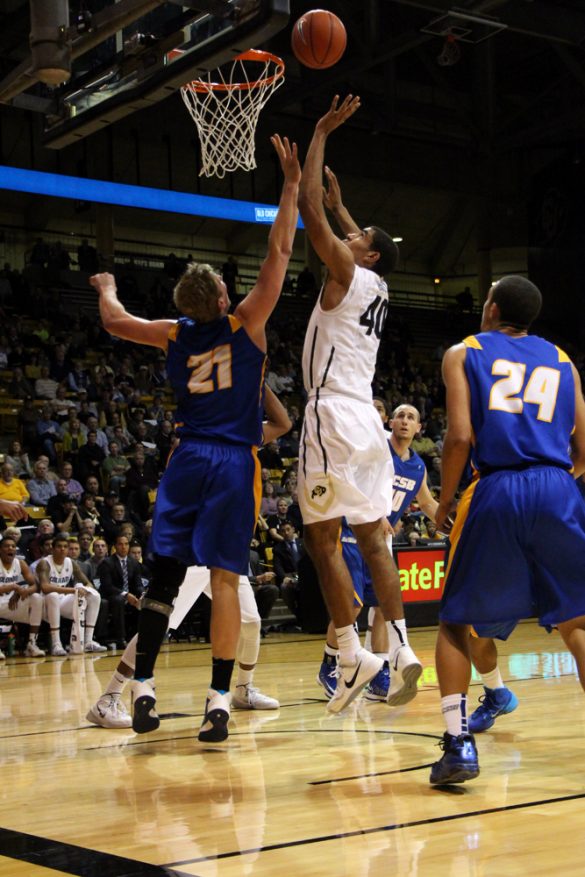 Sophomore forward Josh Scott (40) shoots a lay-up over Mitch Brewe (21) in the lane. (Gray Bender/CU Independent)