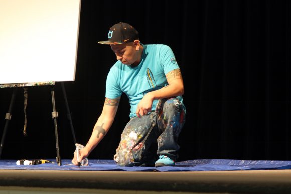 Bunky Echo-Hawk writes ideas for his live painting while receiving inspiration from audience members. (Calyx Ward/CU Independent)