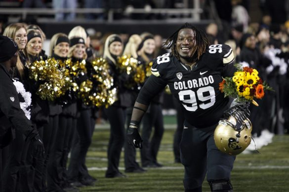 Senior defensive lineman Nate Bonsu (99) smiles as he runs onto the field for the last time during a senior ceremony. (Robert R. Denton/CU Independent)