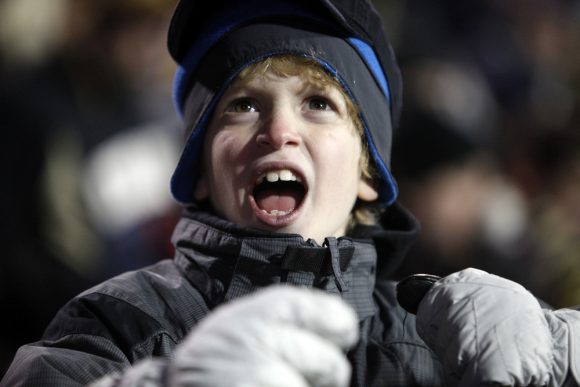 A young fan cheers during the football game. (Robert R. Denton/CU Independent)