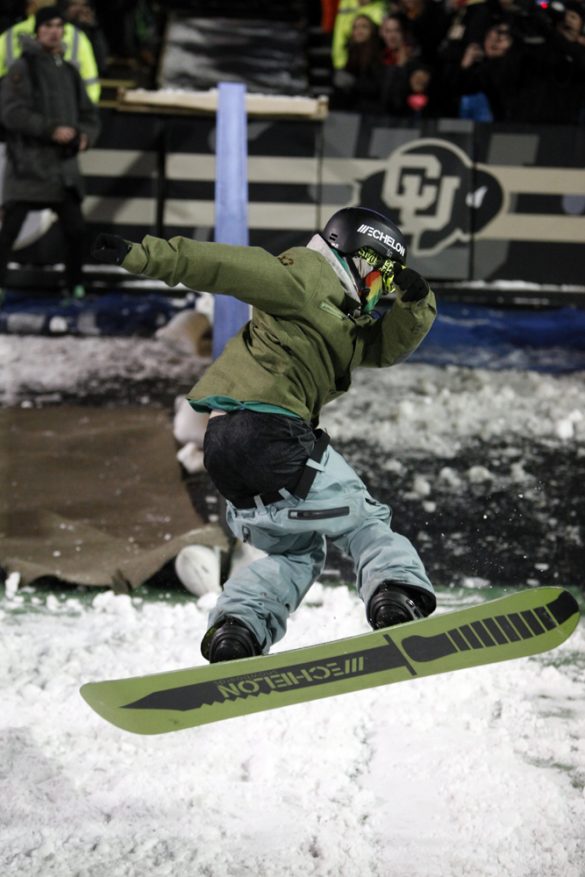 A member of the CU Snowboard Team jumps off a rail during halftime. (Robert R. Denton/CU Independent)