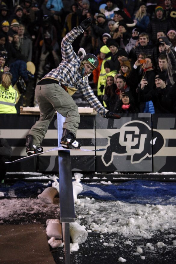 A member of the CU Snowboard Team jumps onto a rail during a halftime performance. (Robert R. Denton/CU Independent)