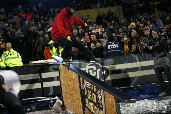 A member of the CU Snowboard Team grinds down a rail during halftime. (Nate Bruzdzinski/CU Independent)