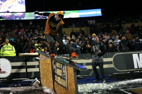 A member of the CU Snowboard Team grinds down a rail during halftime. (Nate Bruzdzinski/CU Independent)