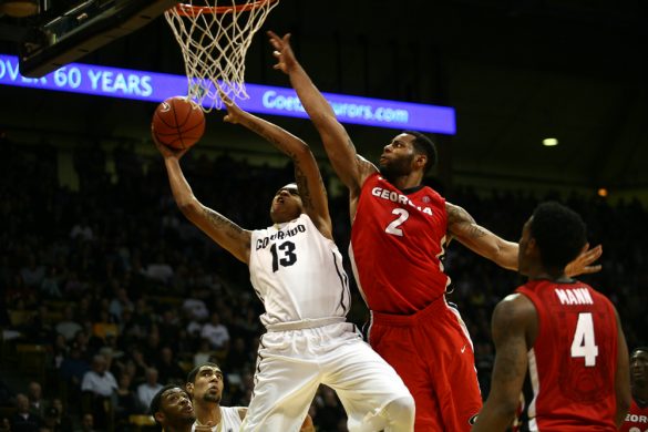Freshman Dustin Thomas (13) grimaces as he puts up a shot while Georgia's Marcus Thornton (2) defends him. (Kai Casey/CU Independent)