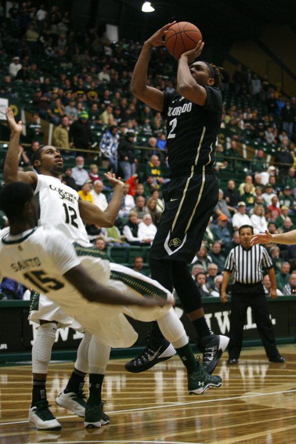 Xavier Johnson (2) shoots in the lane as CSU's Gerson Santon (15) takes a charge. Johnson fouled out of the game after being held scoreless for the first time in his collegiate career. (Kai Casey/CU Independent)