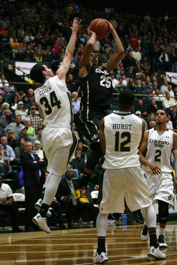 Junior guard Spencer Dinwidide (25) shoots over CSU's David Cohn (34) and Carlton Hurst (12). Dinwiddie scored a game-high 28 points in the rivalry game. (Kai Casey/CU Independent)