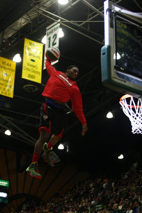 A member of the Rim Rockers skies for a dunk after jumping off a trampoline during a halftime show. The Rim Rockers are a "team of daredevils" that performs at Milwaukee Bucks games and all around the world with "their innovative style and highflying trampoline dunking." (Kai Casey/CU Independent)