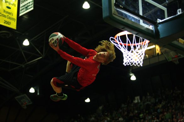 A member of the Rim Rockers flips for a dunk after jumping off a trampoline during a halftime show. The Rim Rockers are a "team of daredevils" that performs at Milwaukee Bucks games and all around the world with "their innovative style and highflying trampoline dunking." (Kai Casey/CU Independent)