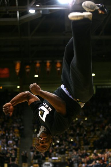 Colorado cheerleader Ozell Williams looks for his landing as he flips across the court during a timeout. (Kai Casey/CU Independent)