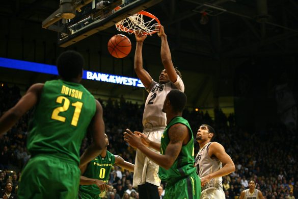 Colorado sophomore forward Xavier Johnson (2) dunks the ball above a host of players. (Kai Casey/CU Independent)