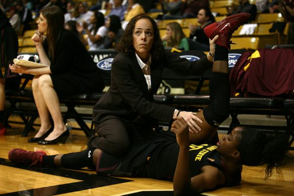 Promise Amukamara (10) gets stretched by a trainer after injuring her leg. (Kai Casey/CU Independent)