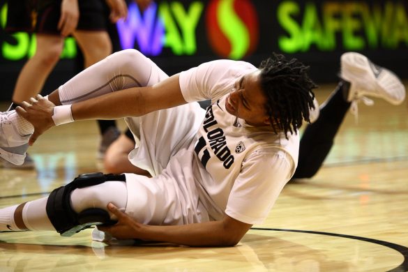 Colorado senior guard Brittany Wilson (11) grimaces as she grabs her ankle after falling to the ground. (Kai Casey/CU Independent)