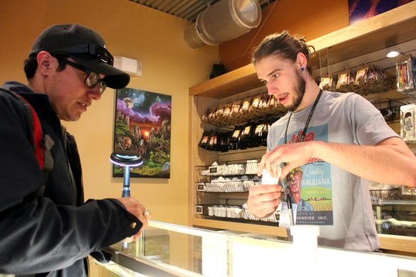Kris Knox, right, a bud tender, helps Kris Bunker of Boulder choose a strain of weed at the Terrapin Care Station. (Kai Casey/CU Independent)