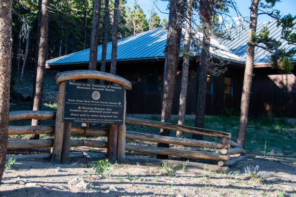 An image of a sign welcoming visitors to the Mountain Research Station, in front of a lodge.