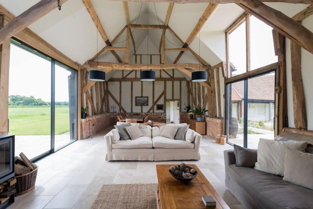 A barn turned into a modern home with a high ceiling and big windows.