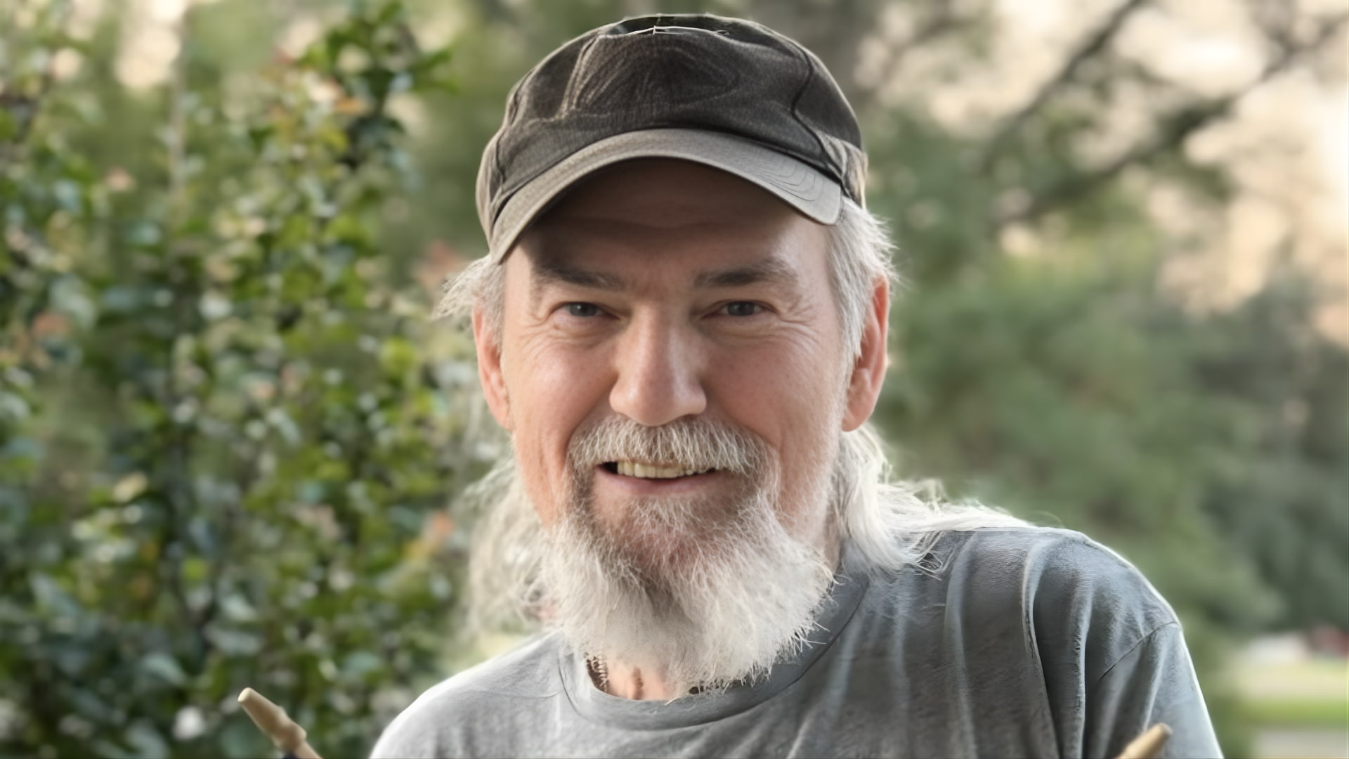 Si Robertson Smiling Outdoors Wearing a Cap