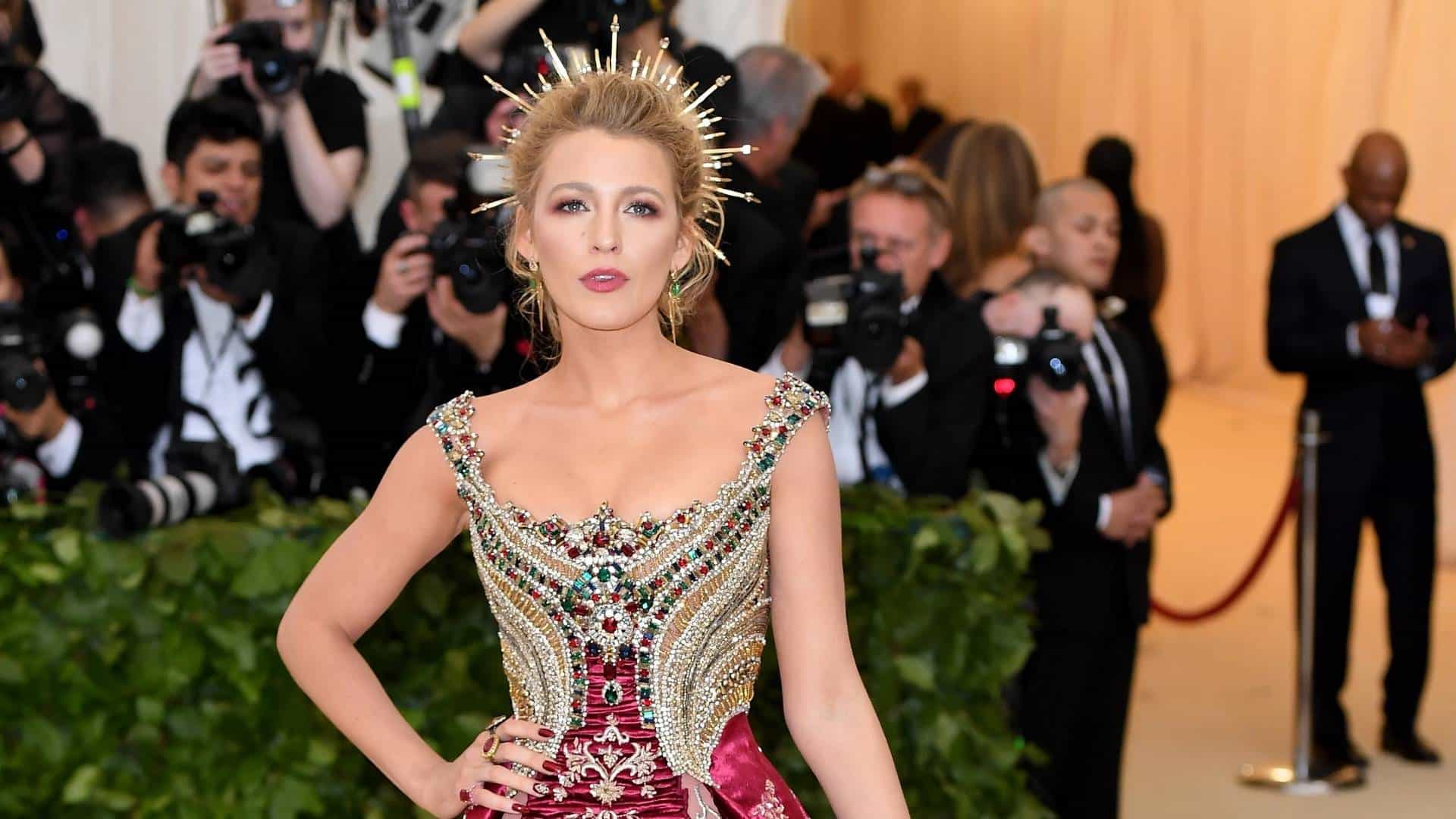 Blake Lively posing at the Met Gala in an embellished gown with dramatic crown hairstyle