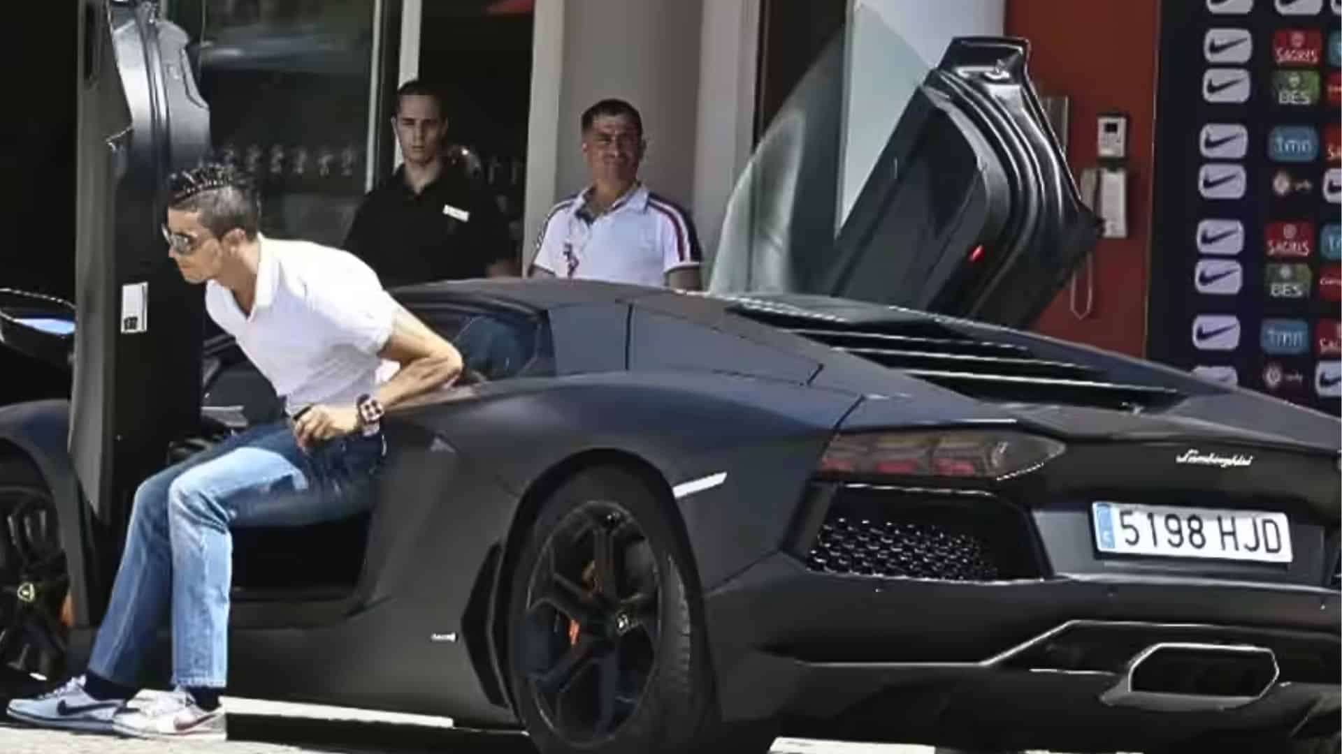 Cristiano Ronaldo stepping out of his matte black Lamborghini Aventador with scissor doors open