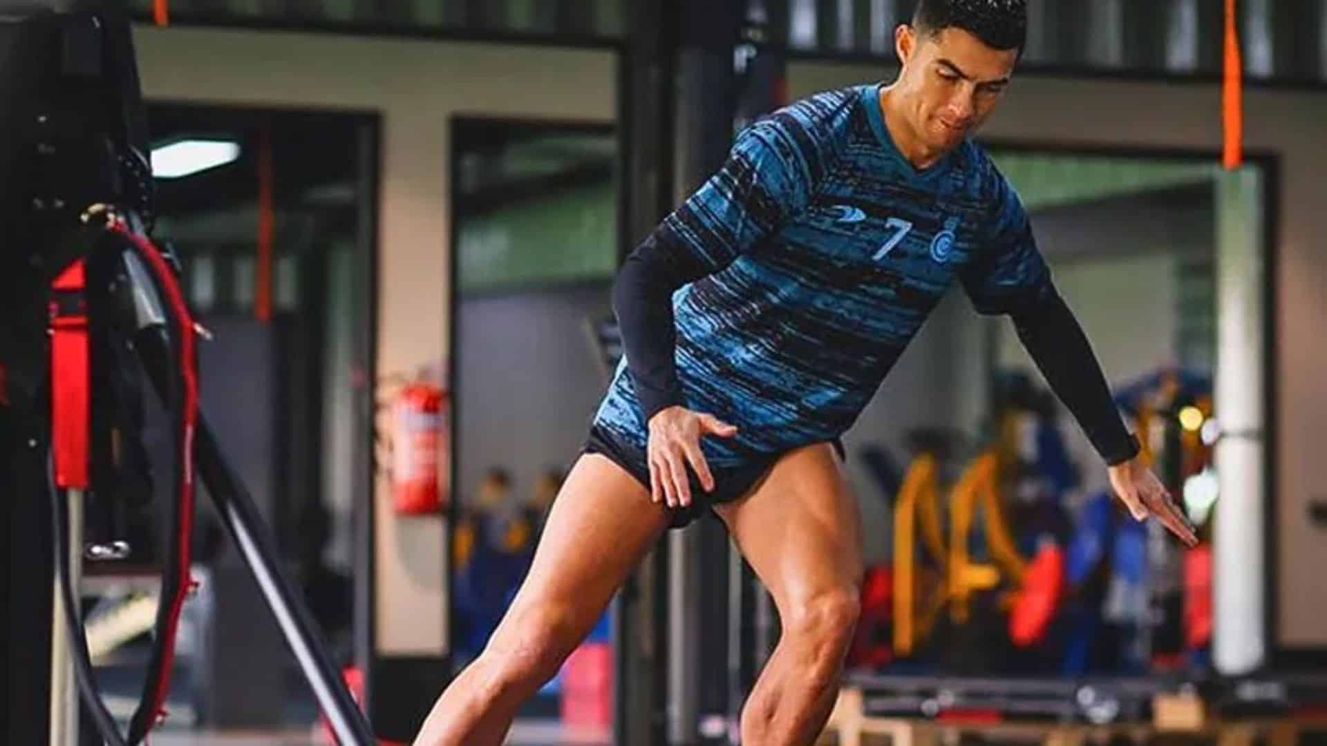 Cristiano Ronaldo training intensively in the gym wearing Al Nassr gear with resistance bands around his ankles