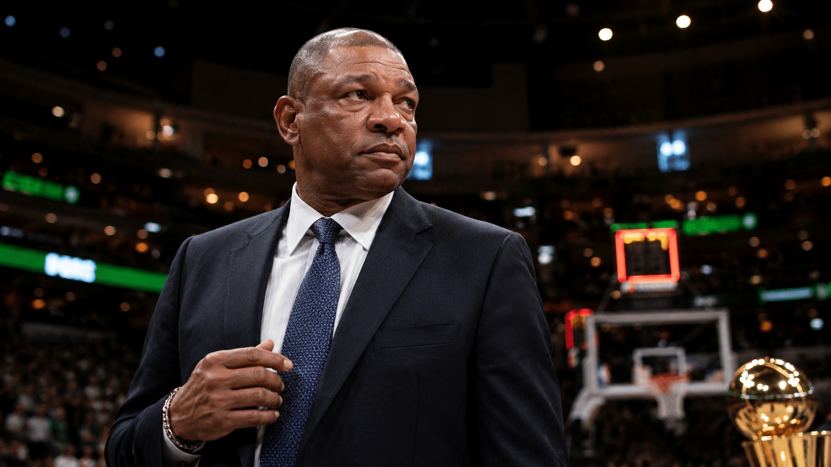 Doc Rivers standing courtside in an NBA arena.
