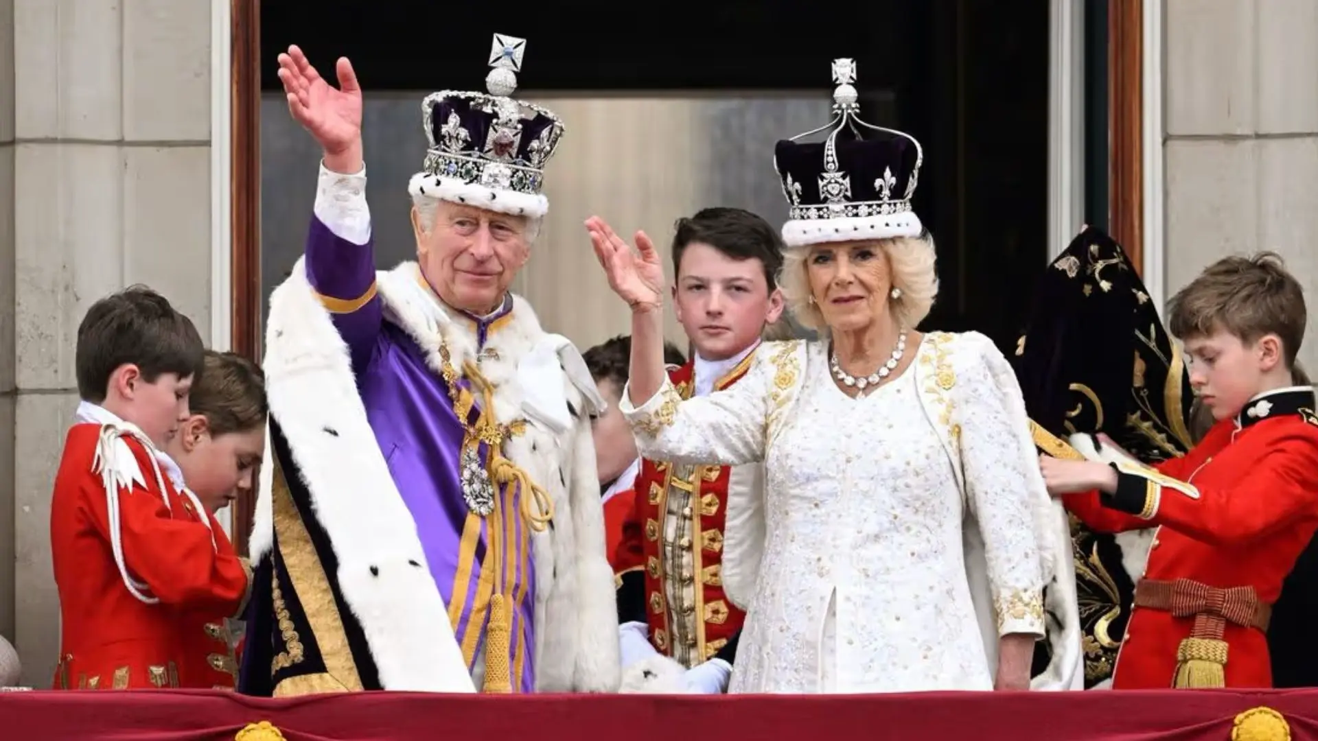 King Charles III and Queen Camilla waving from the Buckingham Palace balcony after the coronation ceremony