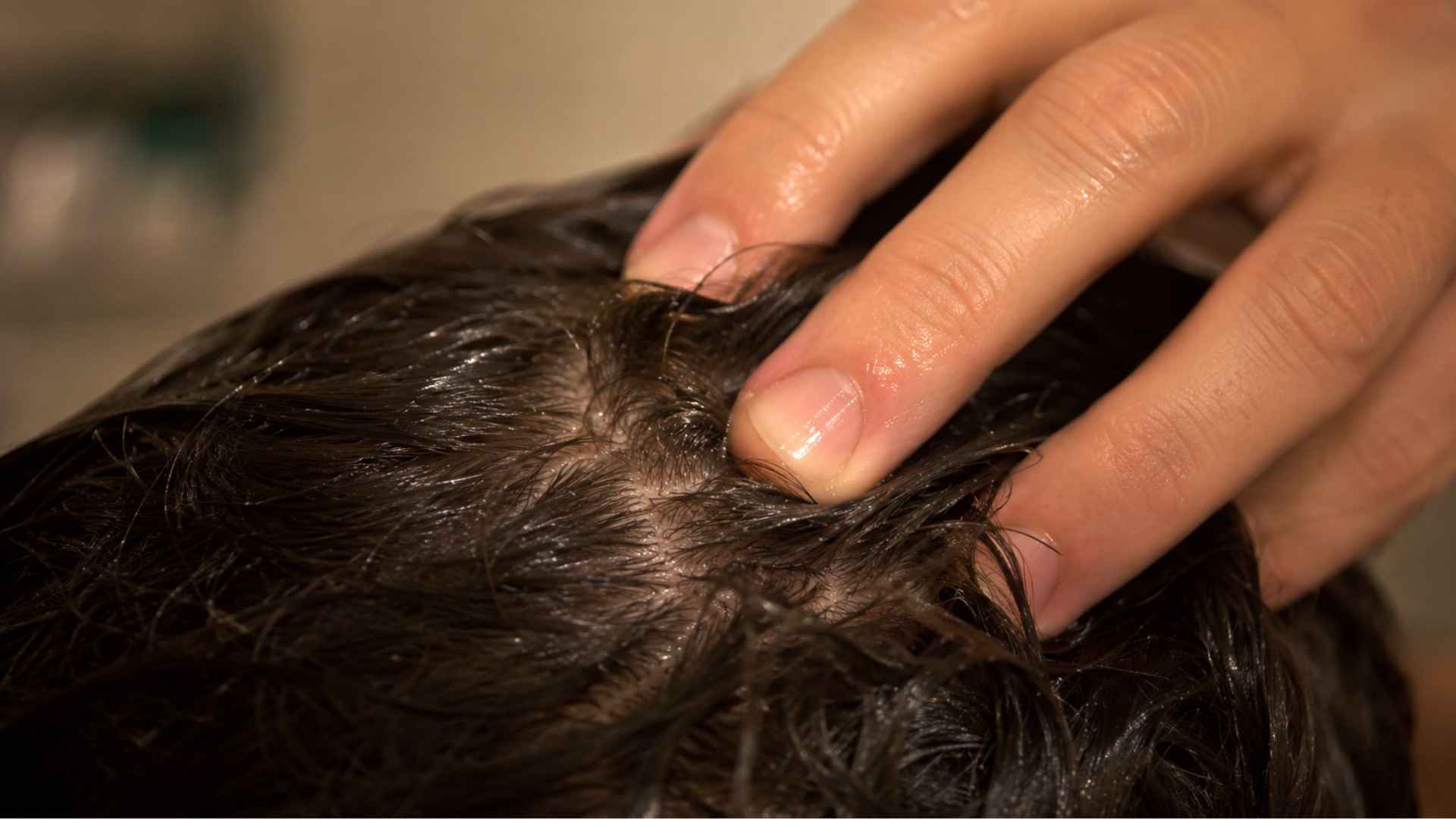 Fingertips massaging scalp gently to boost blood circulation for hair growth