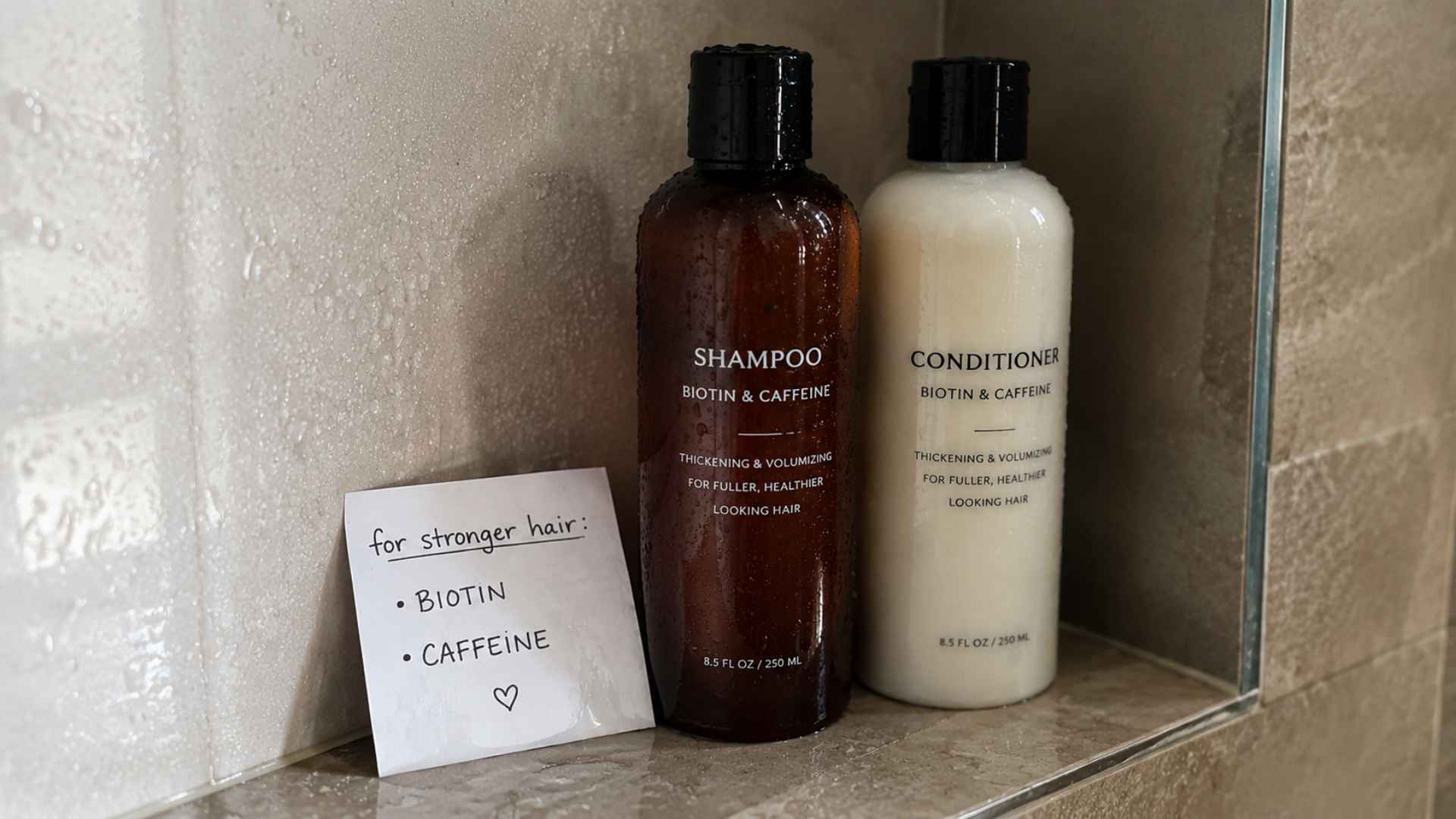 Shampoo and conditioner bottles with biotin & caffeine on shower shelf, note beside them