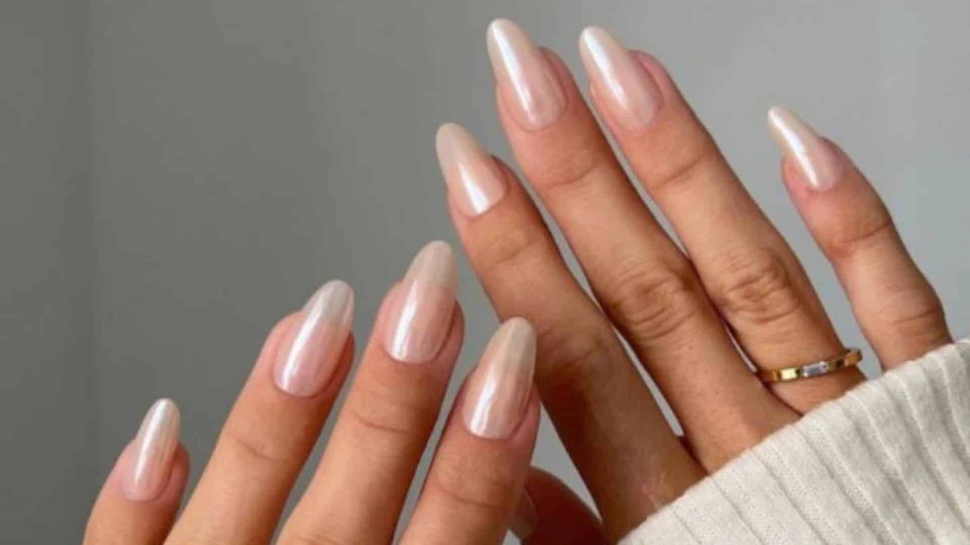 A pair of hands with Subtle Ombre Nails featuring a soft, gradient finish, paired with a simple gold ring