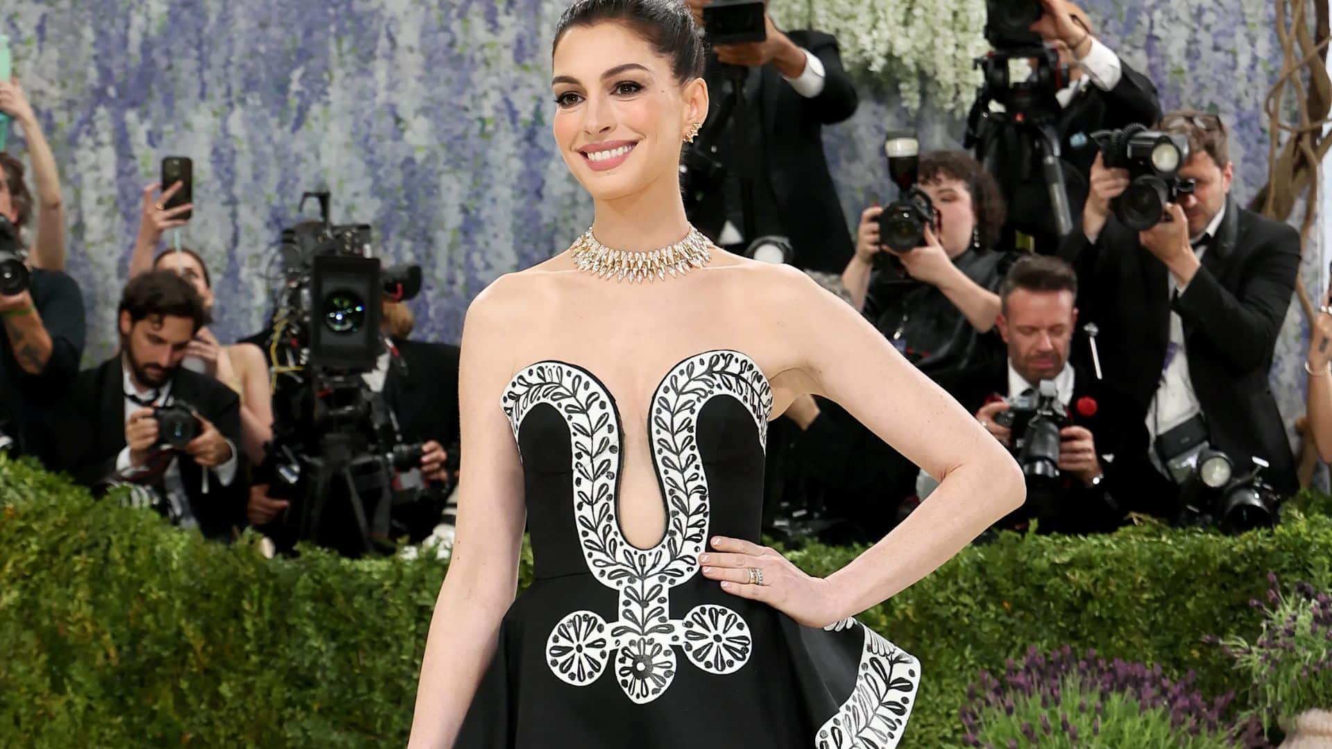 Anne Hathaway wearing a black and white Versace gown with graphic embroidery and strapless silhouette