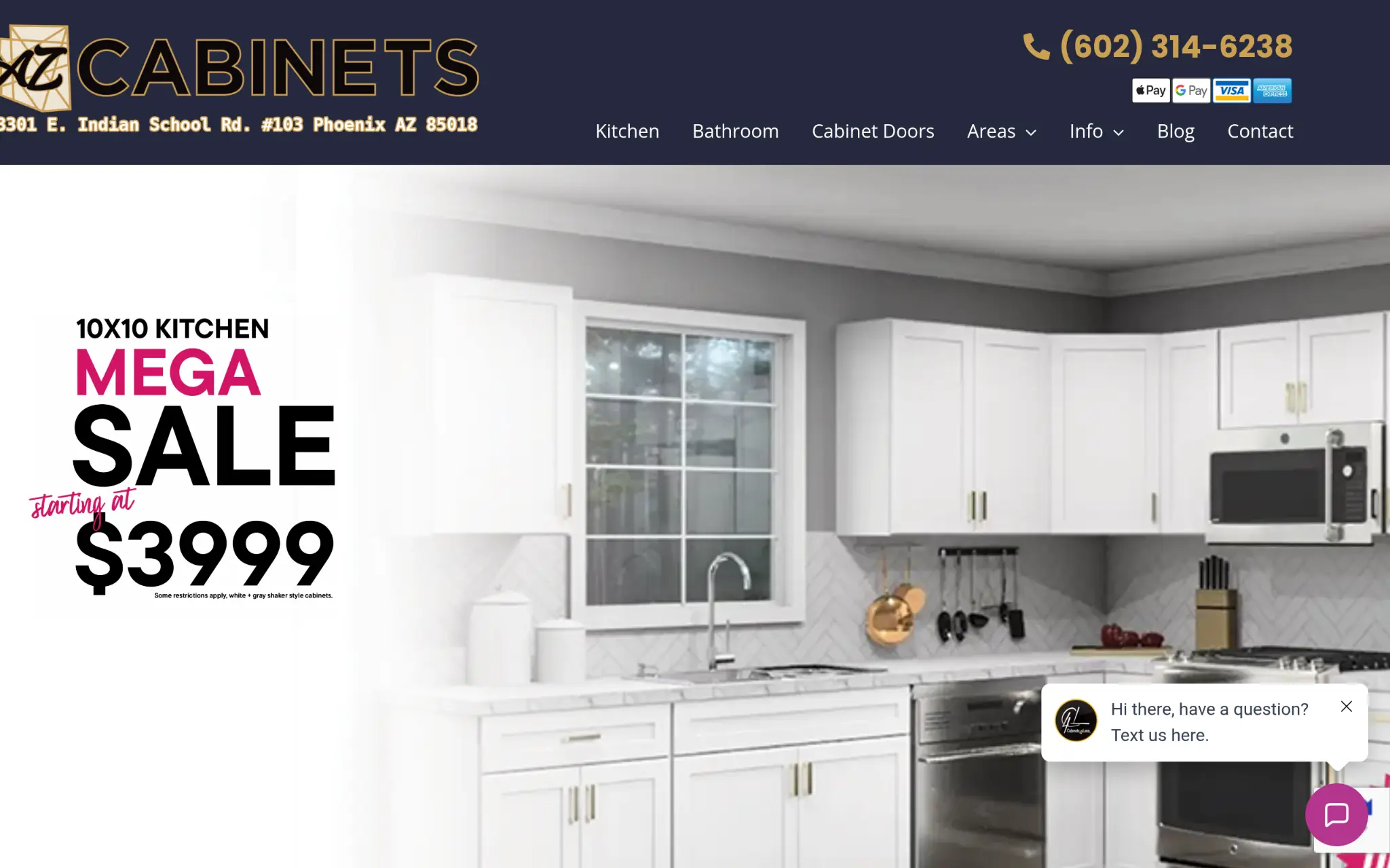 White kitchen cabinets with gold handles, stainless steel appliances, and gray backsplash in modern kitchen