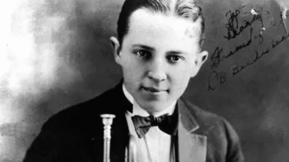 Bix Beiderbecke posing for a photo holding an instrument