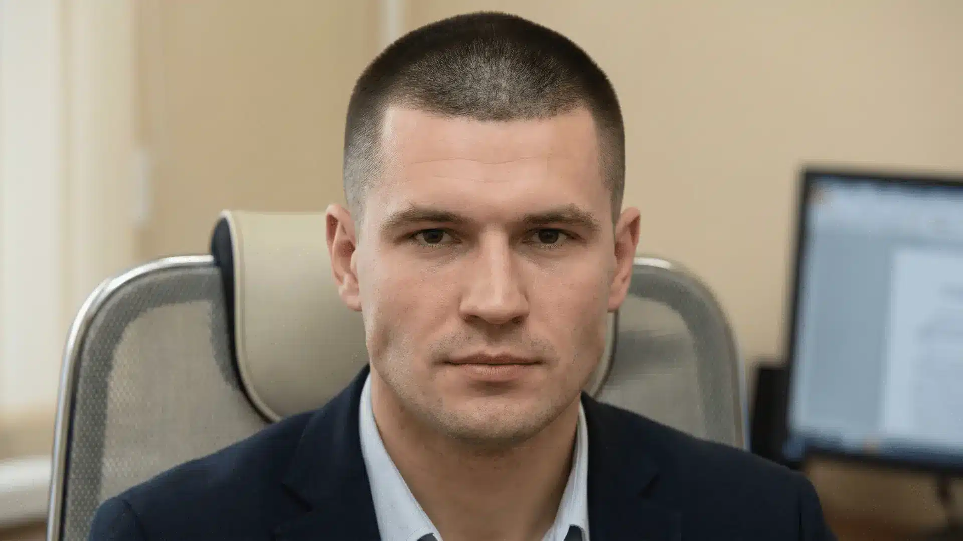 Man with a tidy buzz cut, very short hair all around, front view