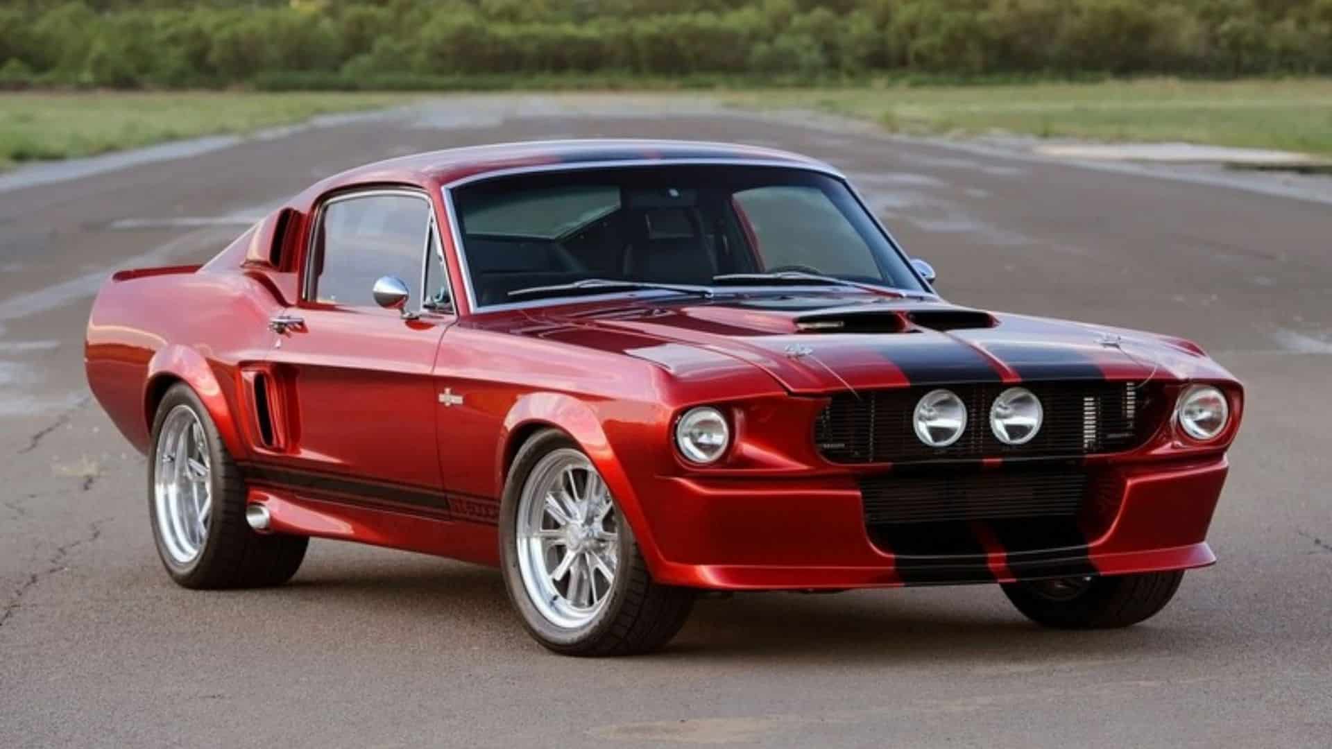 Classic red Ford Mustang Shelby GT500 with black racing stripes parked on an open road