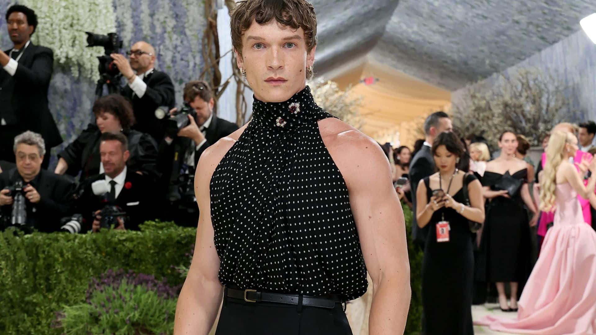 Conor Storrie wearing a sleeveless black Saint Laurent look with polka-dot high-neck detailing at the Met Gala