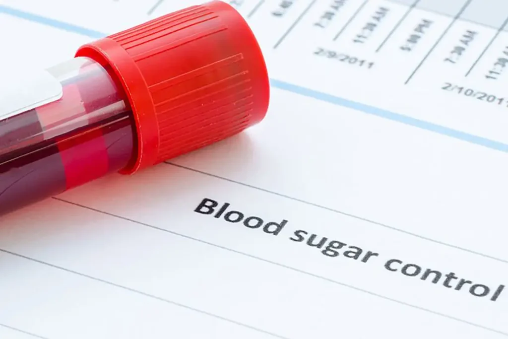 Blood sample vial with red cap on document labeled blood sugar control