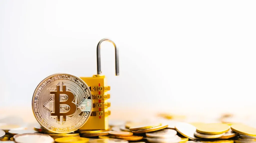 Bitcoin coin next to open combination padlock on pile of coins against white background