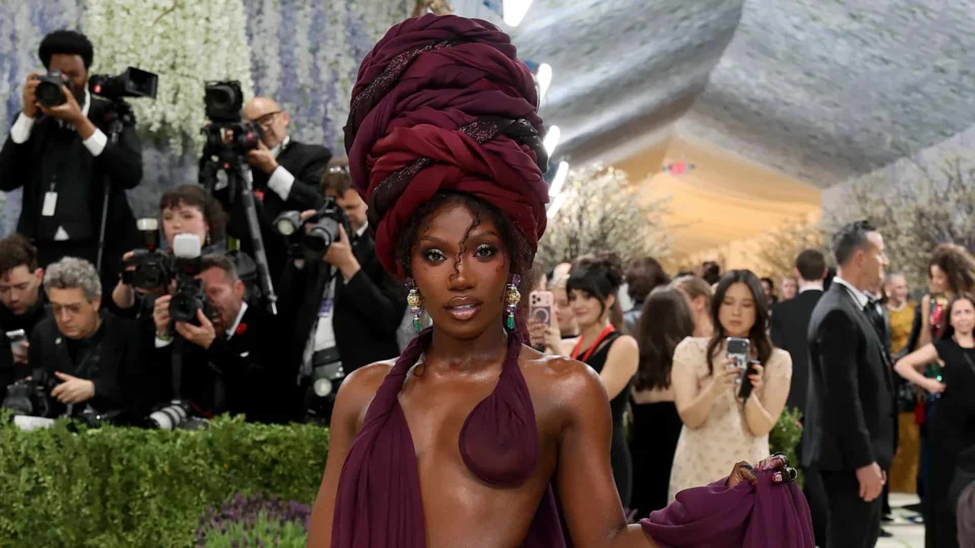 Doechii wearing a dramatic plum Marc Jacobs look with towering wrapped headpiece