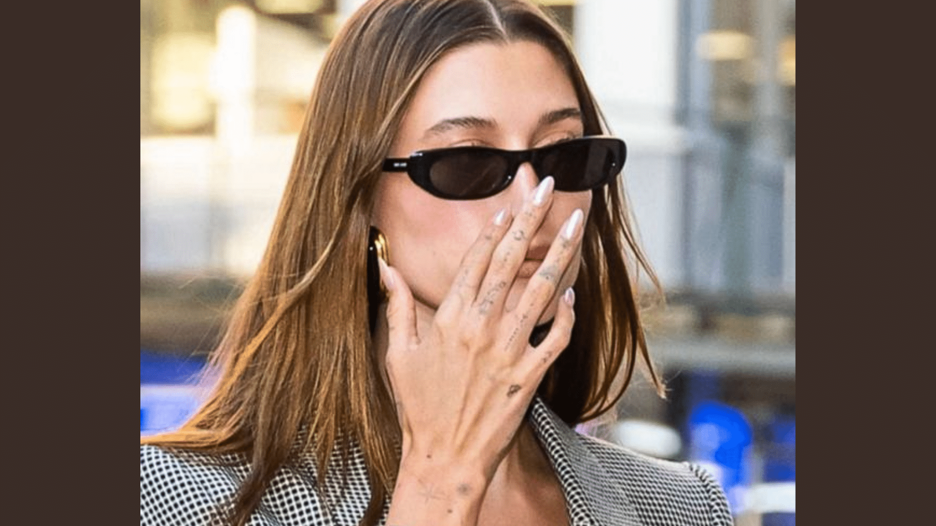 Hailey Bieber showing off Glazed Donut Nails while wearing sunglasses and a chic outfit