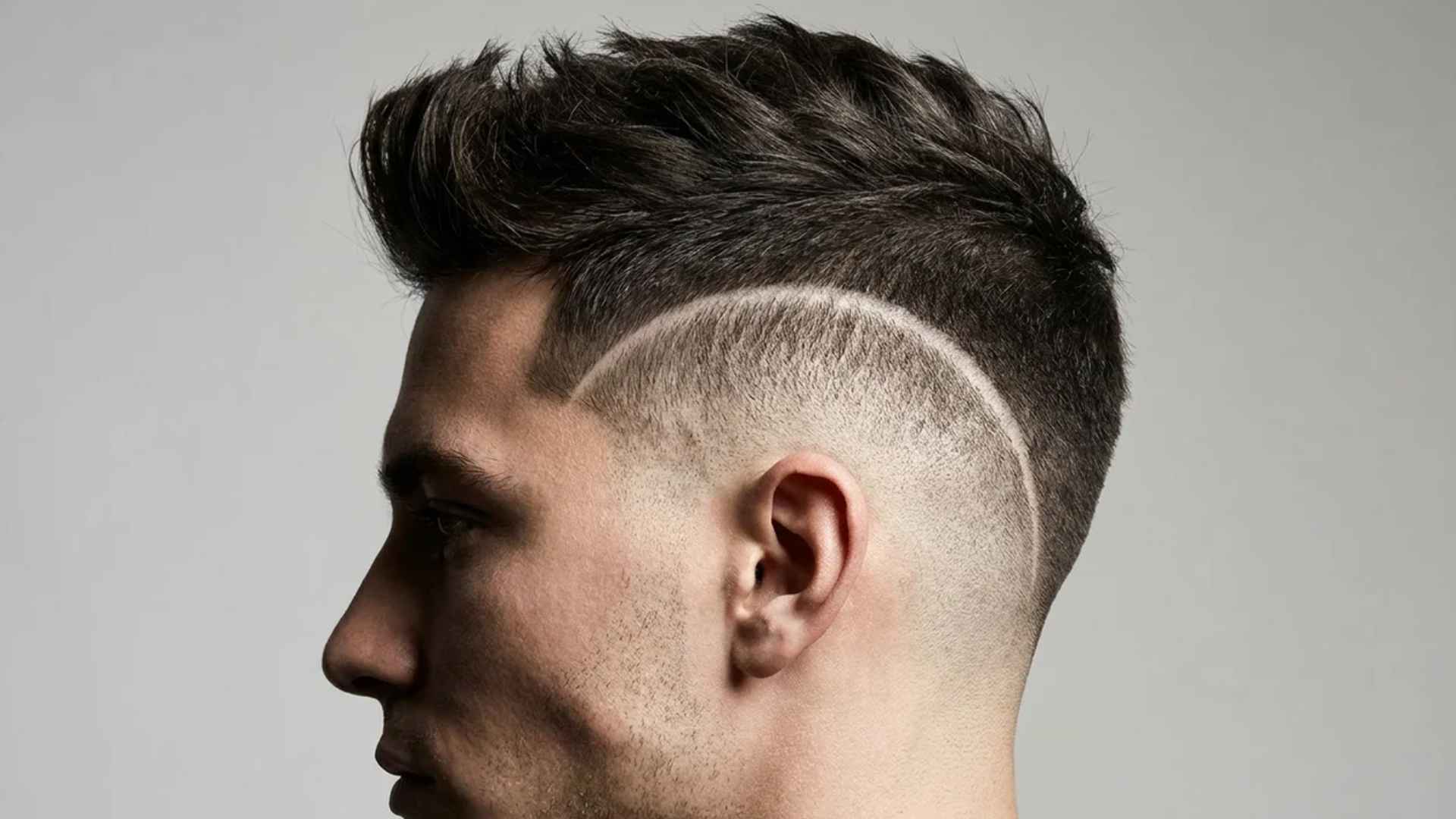 High burst fade curving dramatically around the ear, tapering into bare skin.