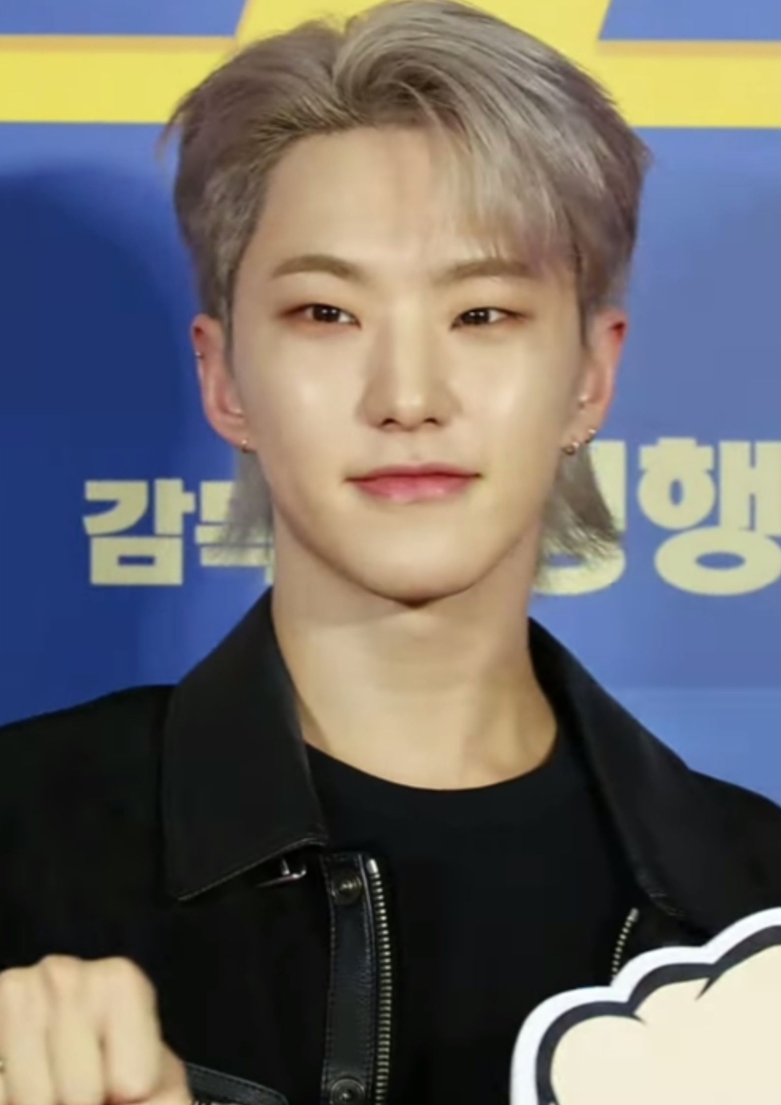 Hoshi of Seventeen wearing a black jacket, posing confidently, known for choreography and Taekwondo skills.
