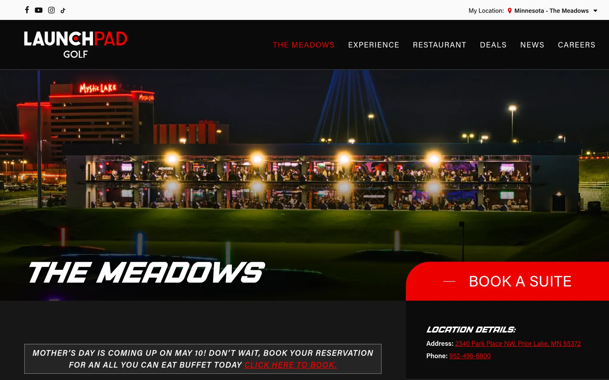 Golf entertainment venue lit at night with stacked bays and bright neon lights