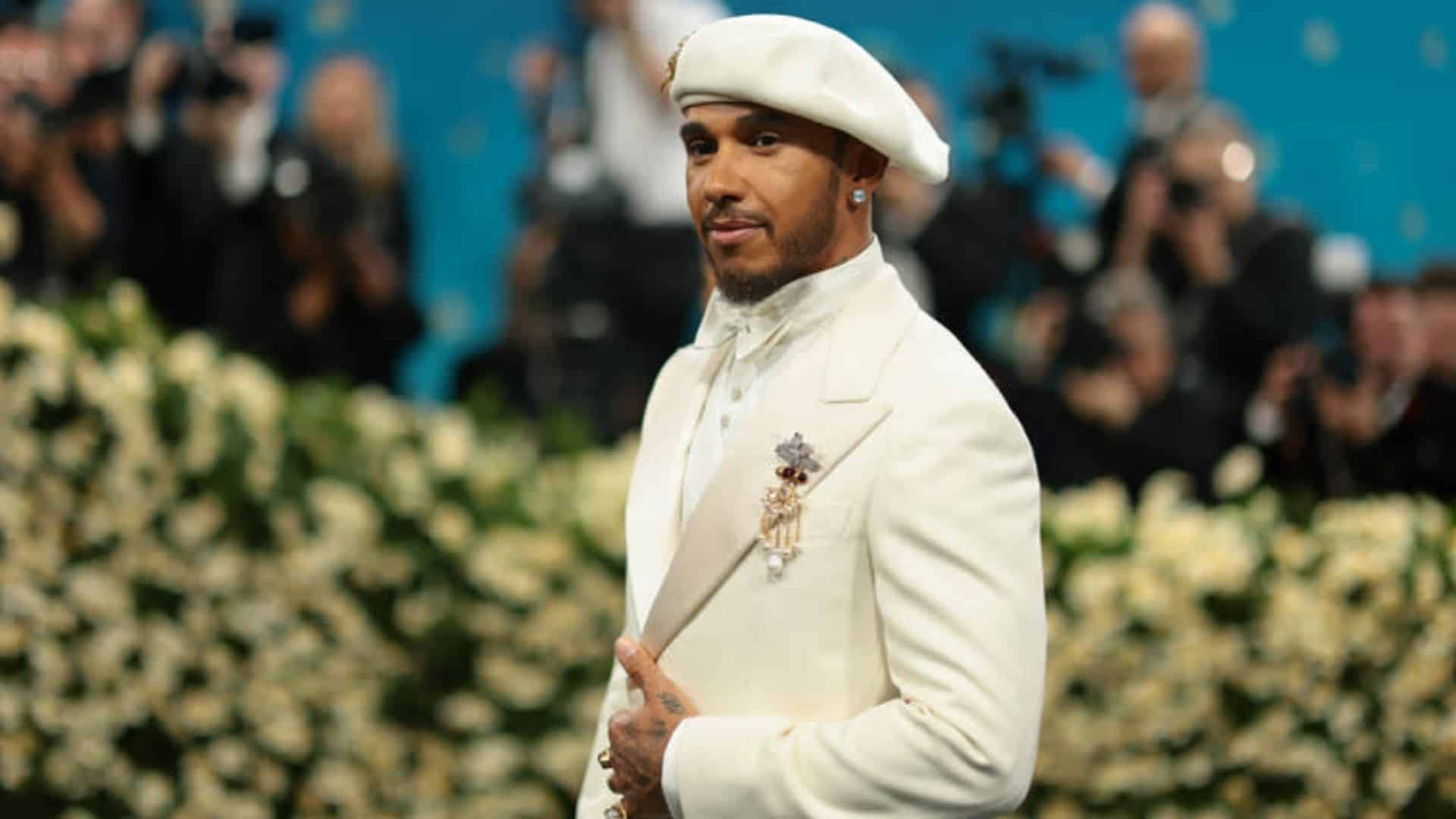 Lewis Hamilton wearing a refined ivory Wales Bonner suit with beret and jeweled brooch