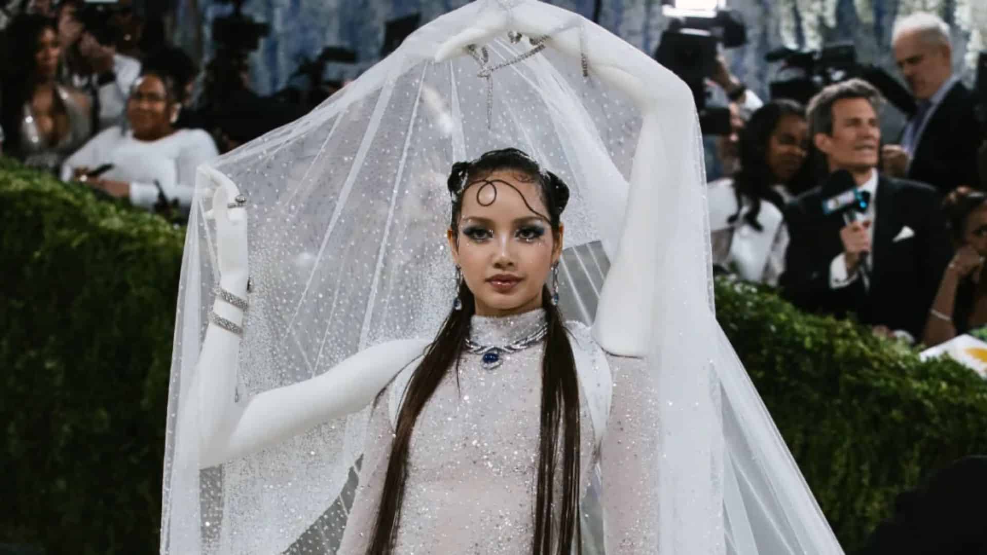 Lisa wearing a sparkling white Robert Wun couture look with dramatic veil and sculptural gloves at the Met Gala