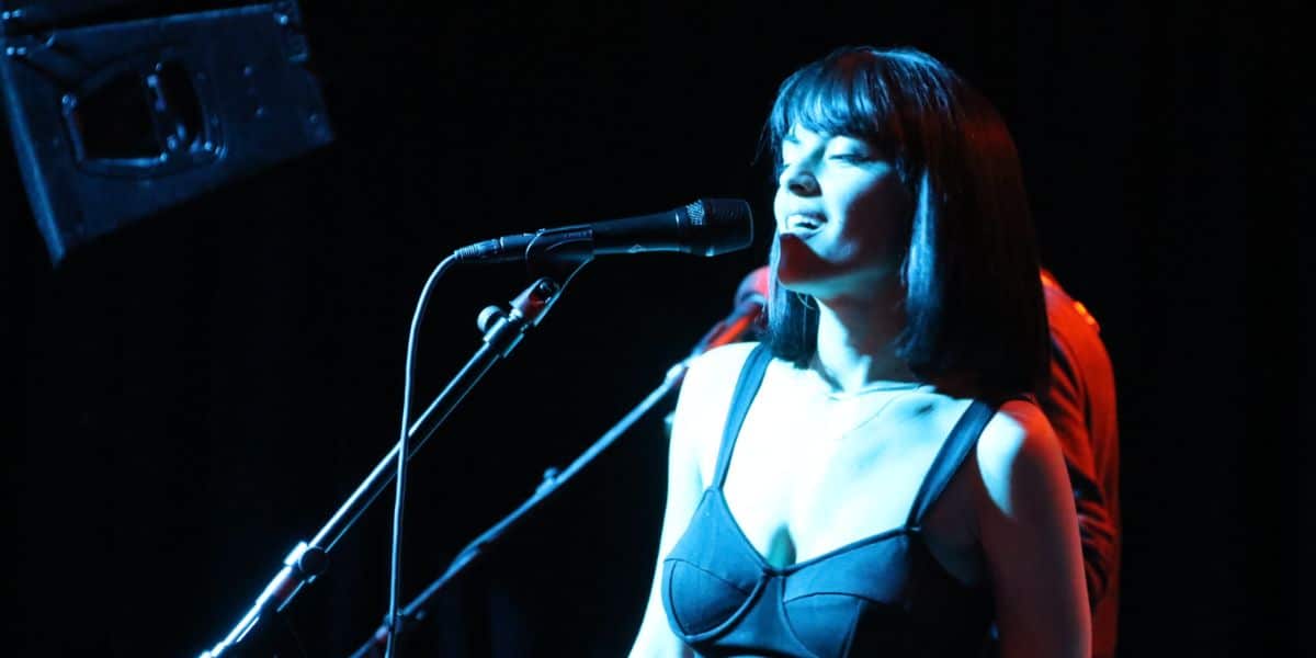 Maria Zardoya singing lead vocals and playing guitar on stage with The Marias